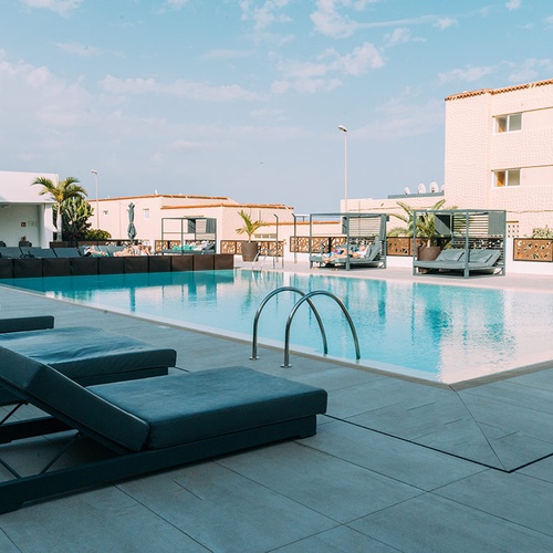 Camas solares junto a piscina de 001 Hotels Corporativa.
