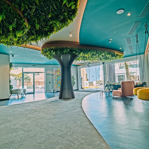 Lujoso lobby de 001 Hoteles: Corporativa con decoración de árboles y vegetación exuberante.
