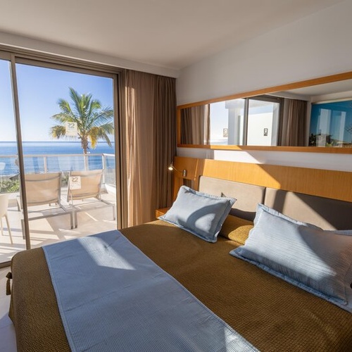 Habitación con vistas al mar en 001 Hotels: Corporativa. Balcón con tumbonas y mesa.