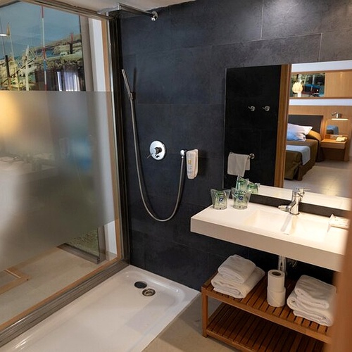 Habitación moderna en 001 Hotels: Corporativa, con balcón, cama cómoda y espejo amplio.