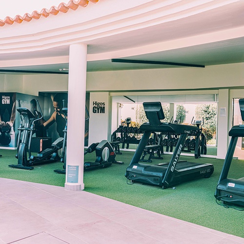Gimnasio al aire libre en 001 Hotels Corporativa con cintas de correr y elípticas.