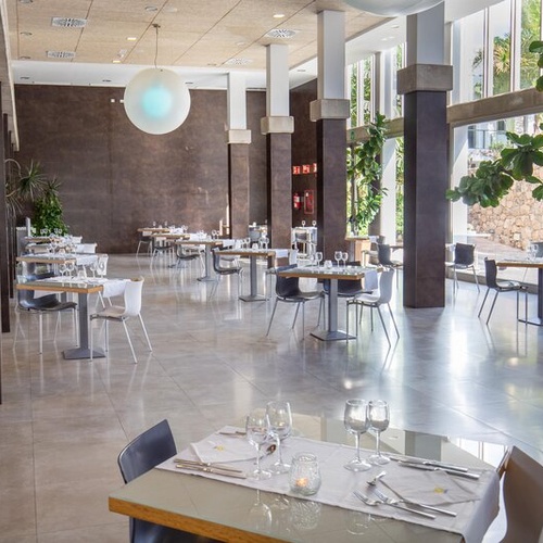 Restaurante elegante en 001 Hotels: Corporativa, con mesas y sillas modernas.