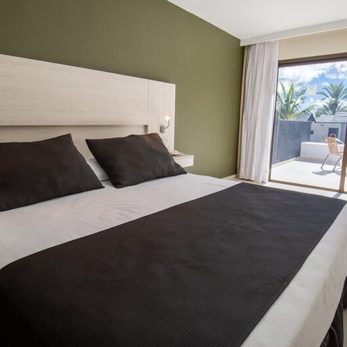 Habitación doble con balcón y vistas a palmeras en 001 Hotels: Corporativa.