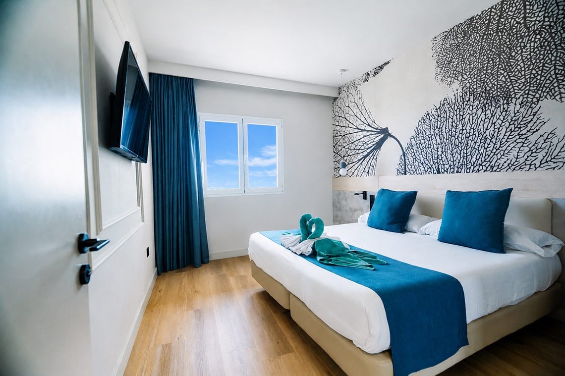 001 Higos Beach: Modernes Hotelzimmer mit 2 Betten, blauen Kissen und Meerblick in Costa Calma.