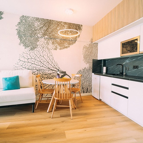 Habitación moderna con sofá, mesa y cocina equipada en 001 Hotels Corporativa.