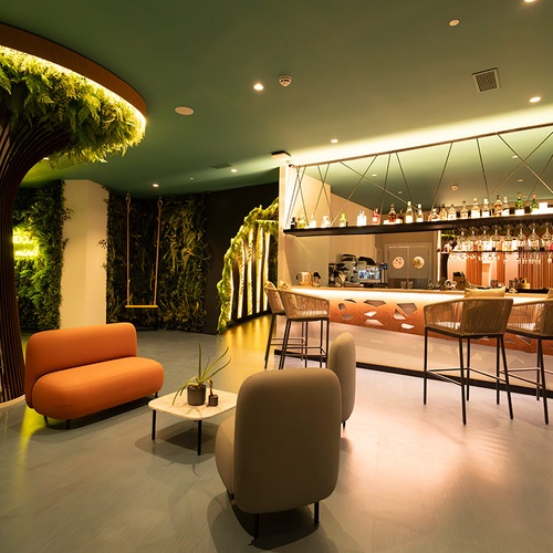 Bar moderno y sala de estar con temática natural en 001 Hotels: Corporativa.