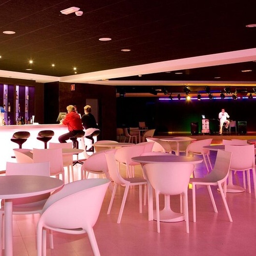 Bar y lounge moderno en 001 Hotels: Corporativa con luces vibrantes y asientos cómodos.
