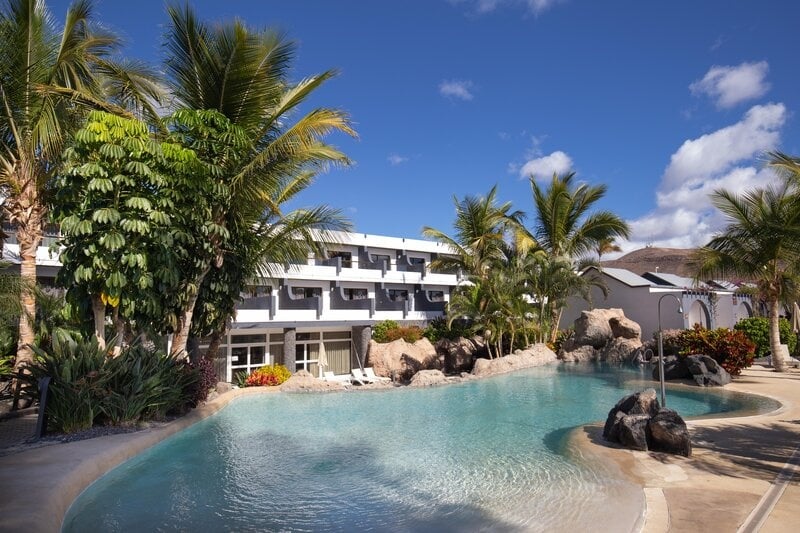 Poolbereich im 001 Hotels: Corporativa mit Palmen und Sonnenschein