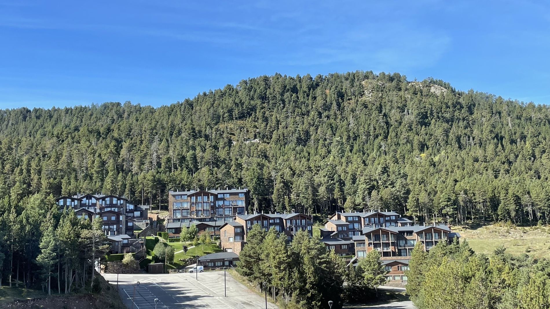 un pueblo en la ladera de una montaña rodeado de árboles y edificios