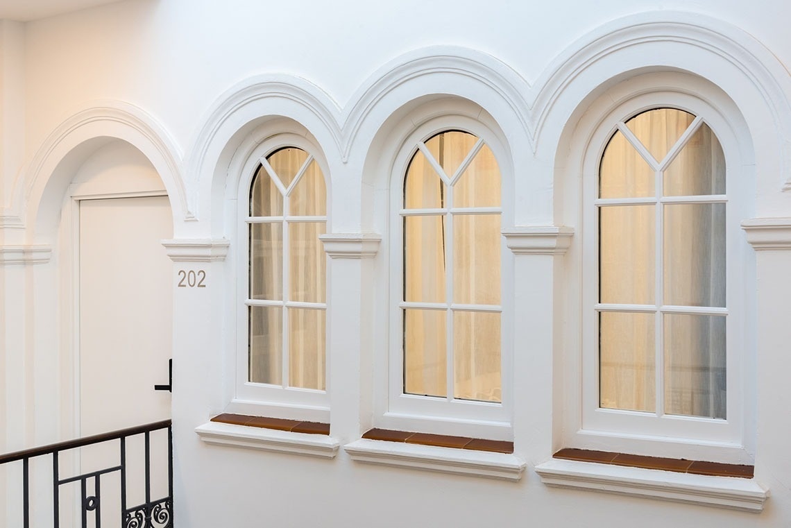 un edificio blanco con tres ventanas y la puerta 202