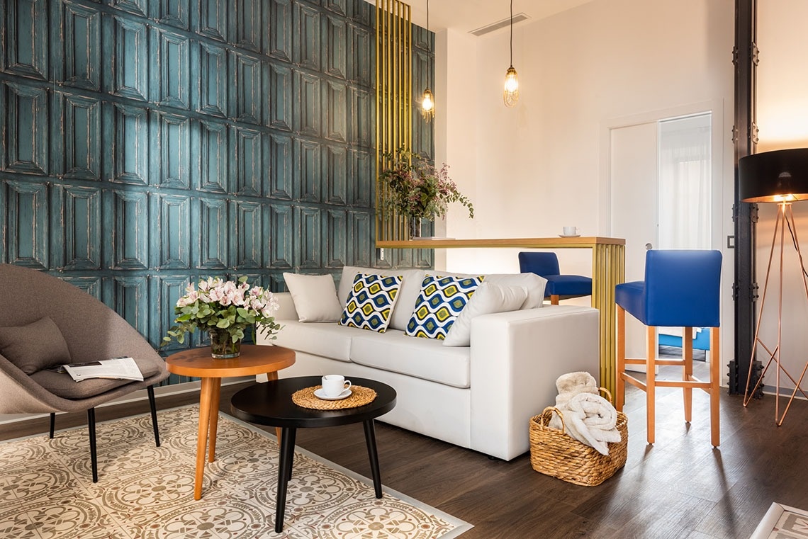 una sala de estar con un sofá blanco y sillas azules