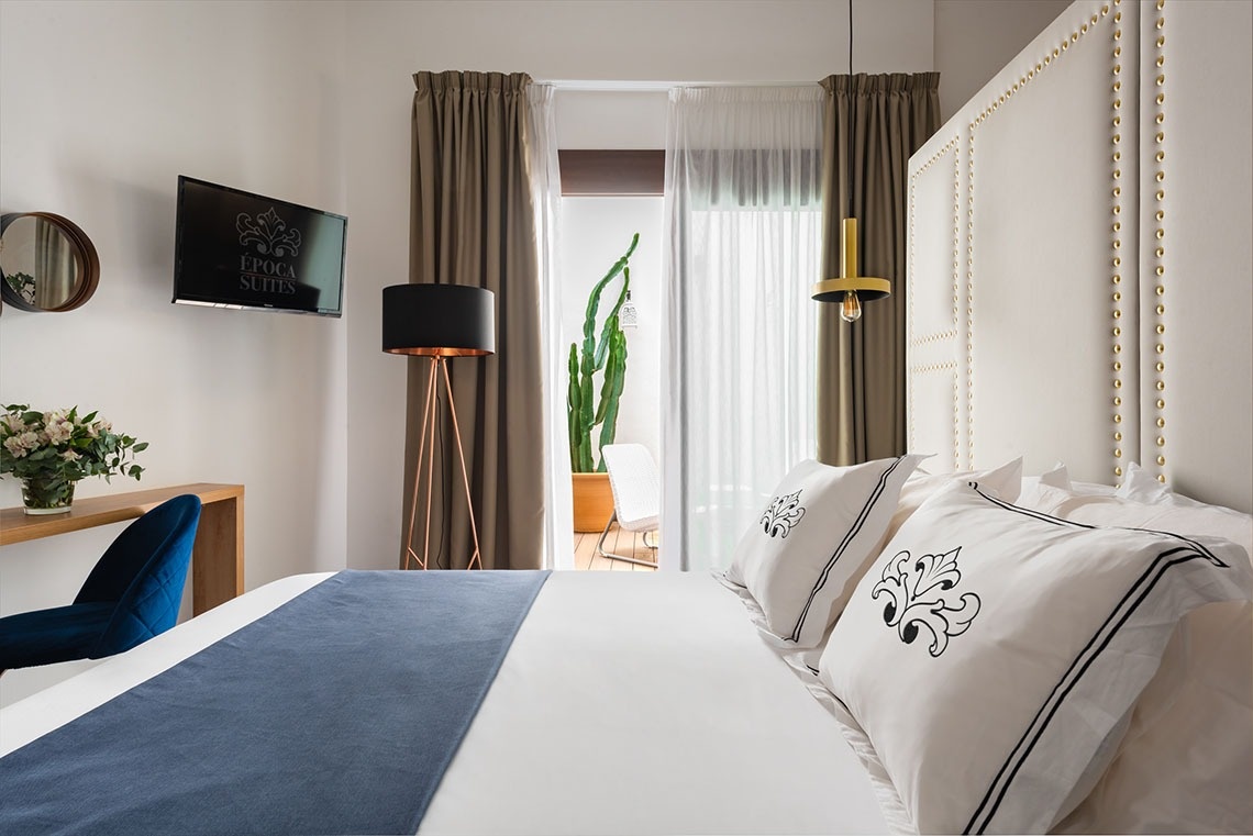 una habitación con una cama y una televisión con la palabra epoca encima