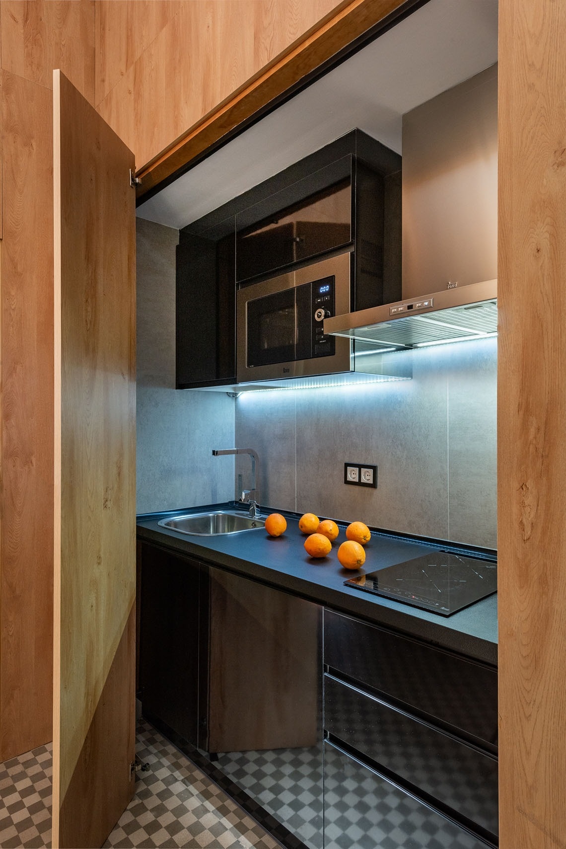 una cocina con electrodomésticos negros y naranjas en la mesa