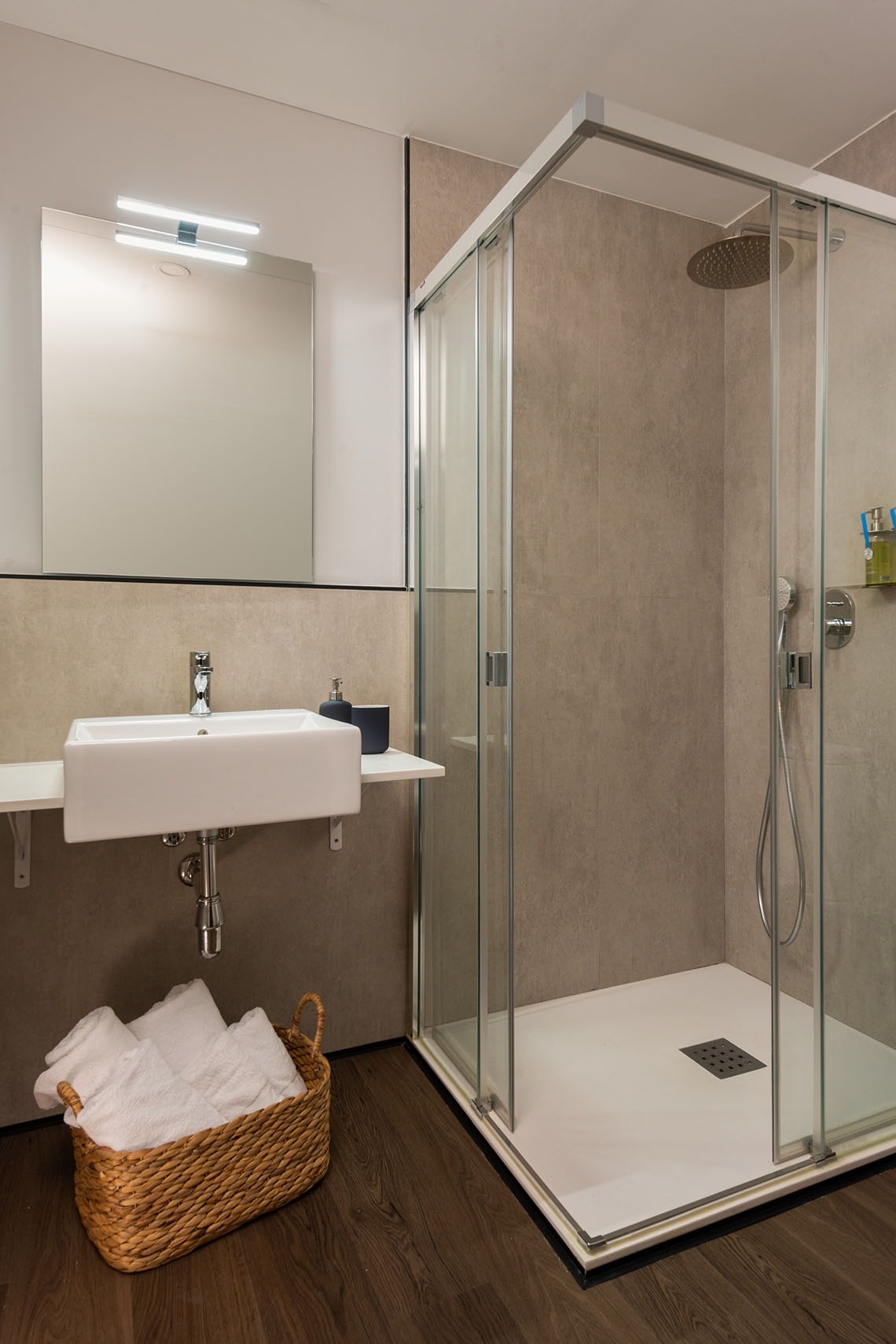 un baño con lavabo y ducha con puerta corrediza de vidrio
