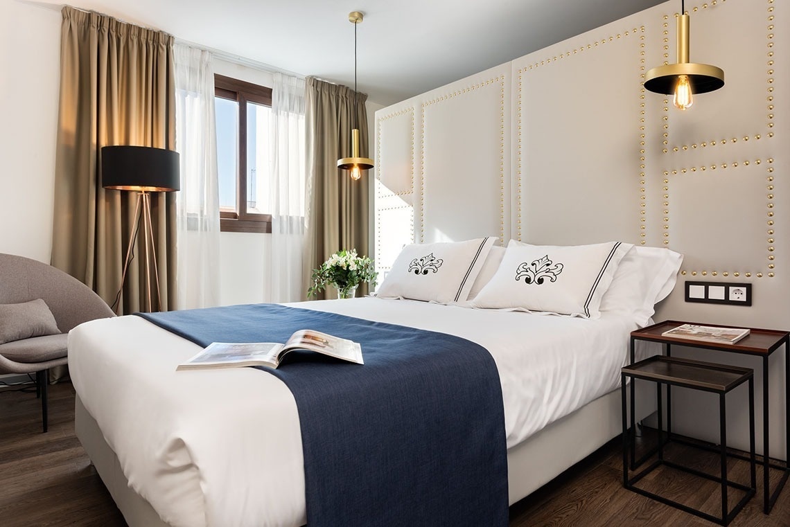 una cama en una habitación de hotel con un libro encima