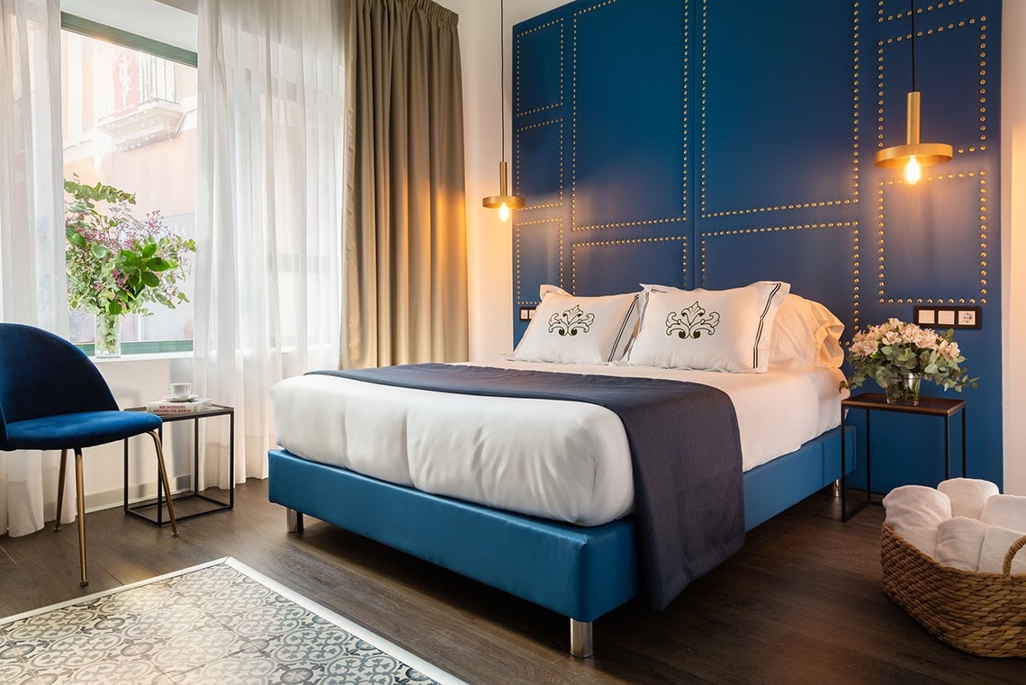 una habitación con una cama azul y una pared azul