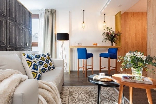 una sala de estar con un sofá y taburetes azules