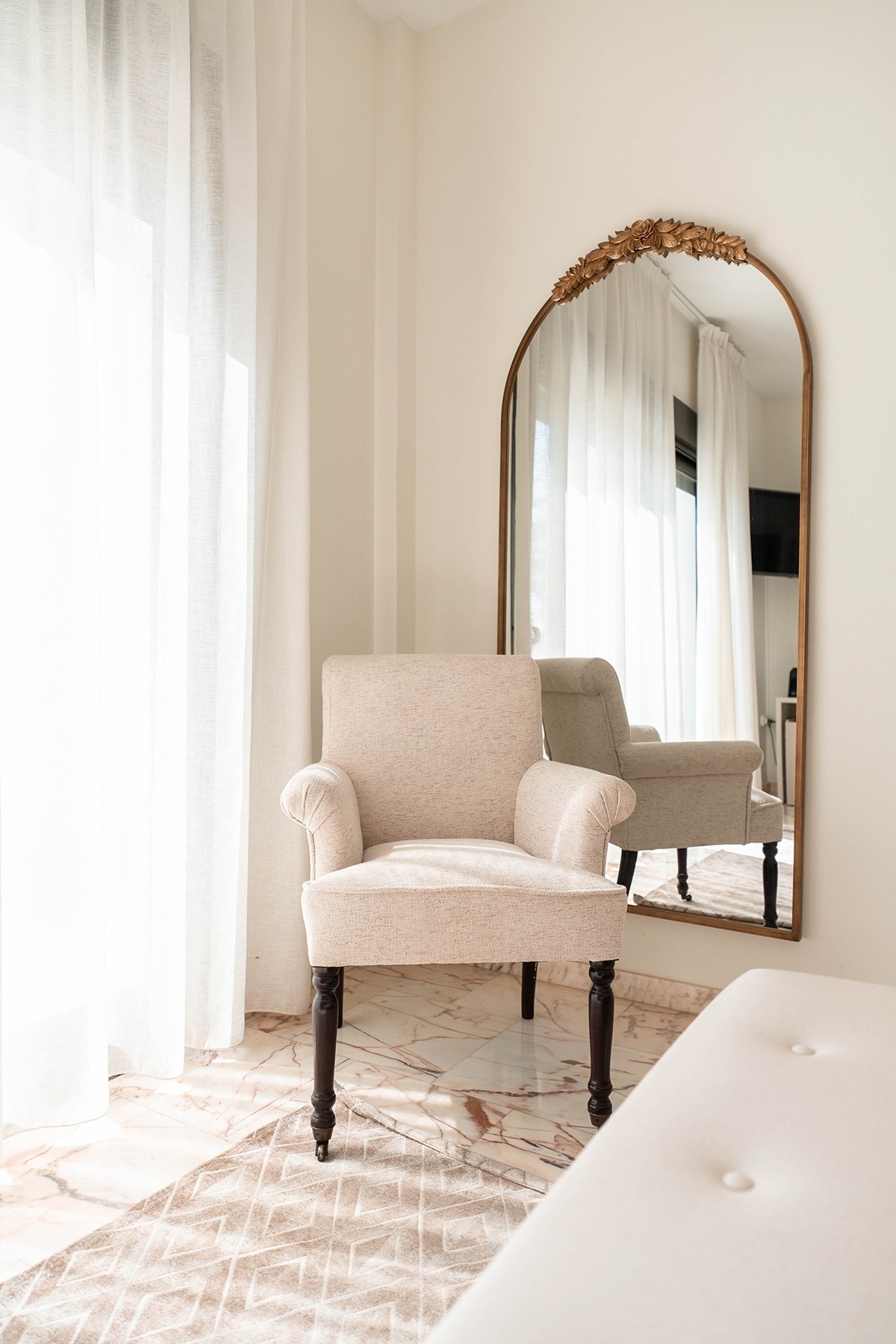 a chair in front of a large mirror in a room