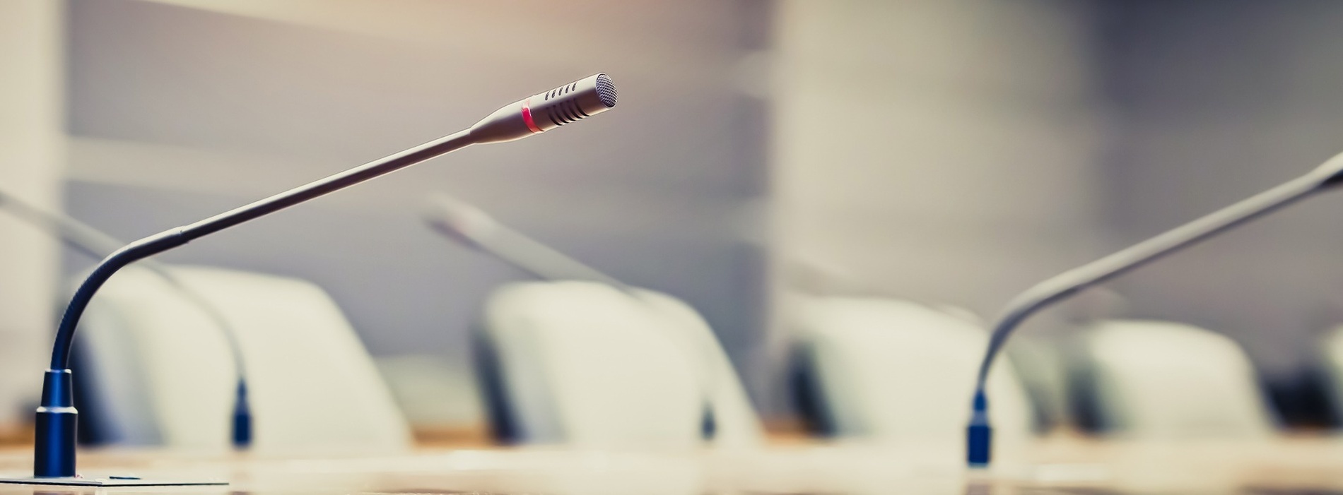 a row of microphones are lined up in a conference room