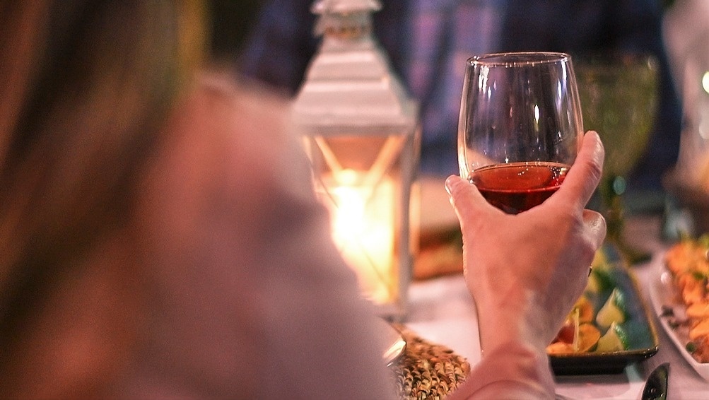 a person is holding a glass of wine in their hand