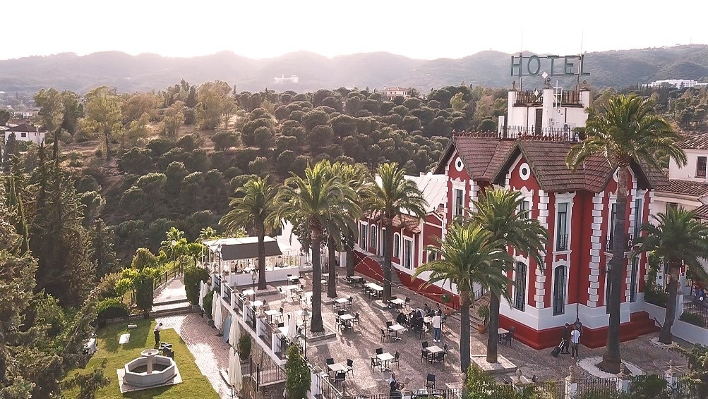 an aerial view of a hotel surrounded by palm trees