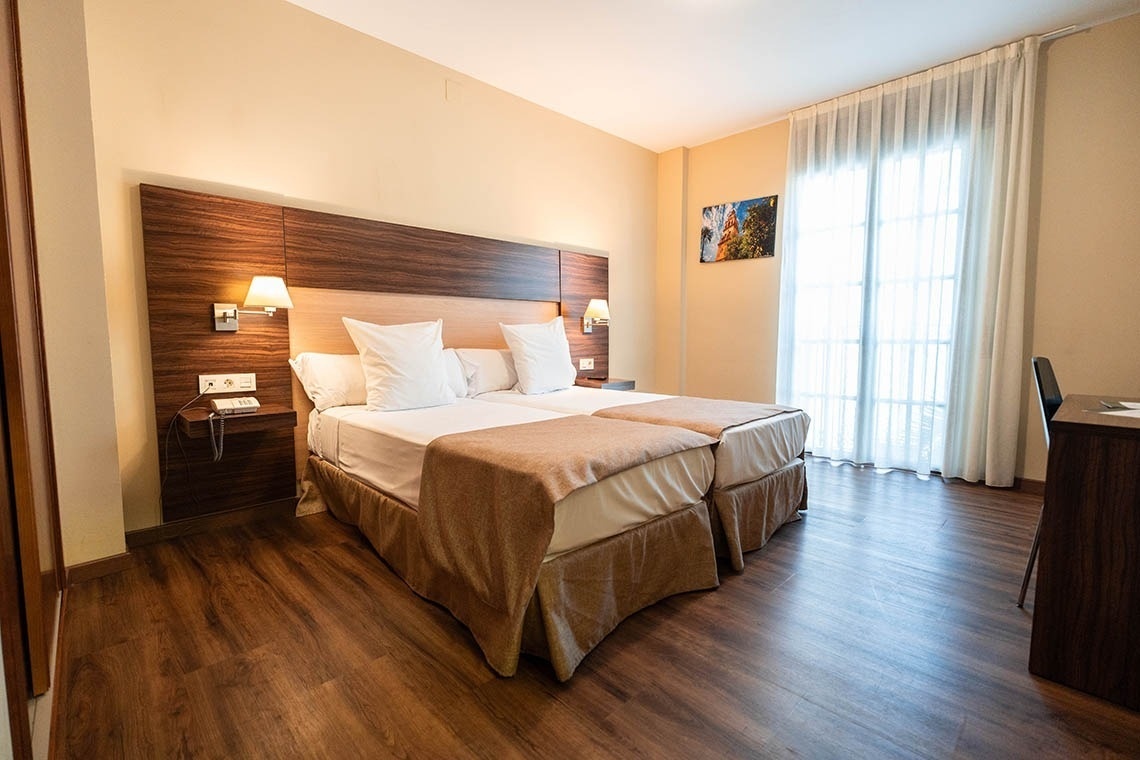 a hotel room with two beds and a picture on the wall