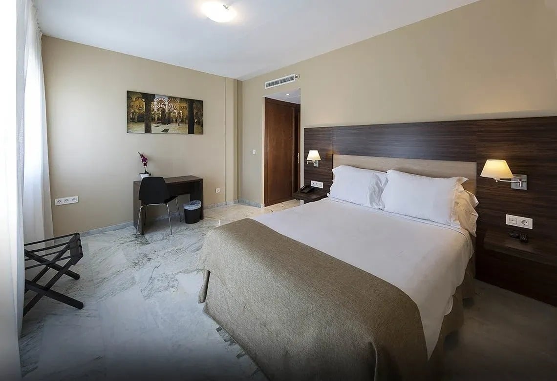 una habitación de hotel con una cama y un escritorio