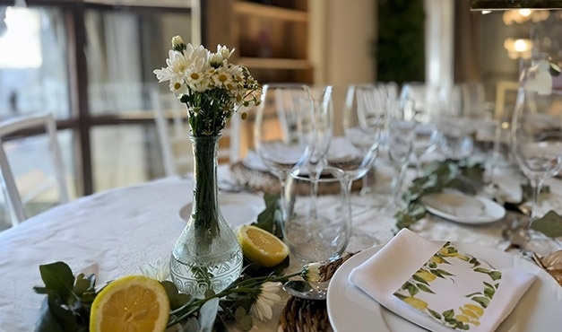 a table with a vase of flowers and lemons on it