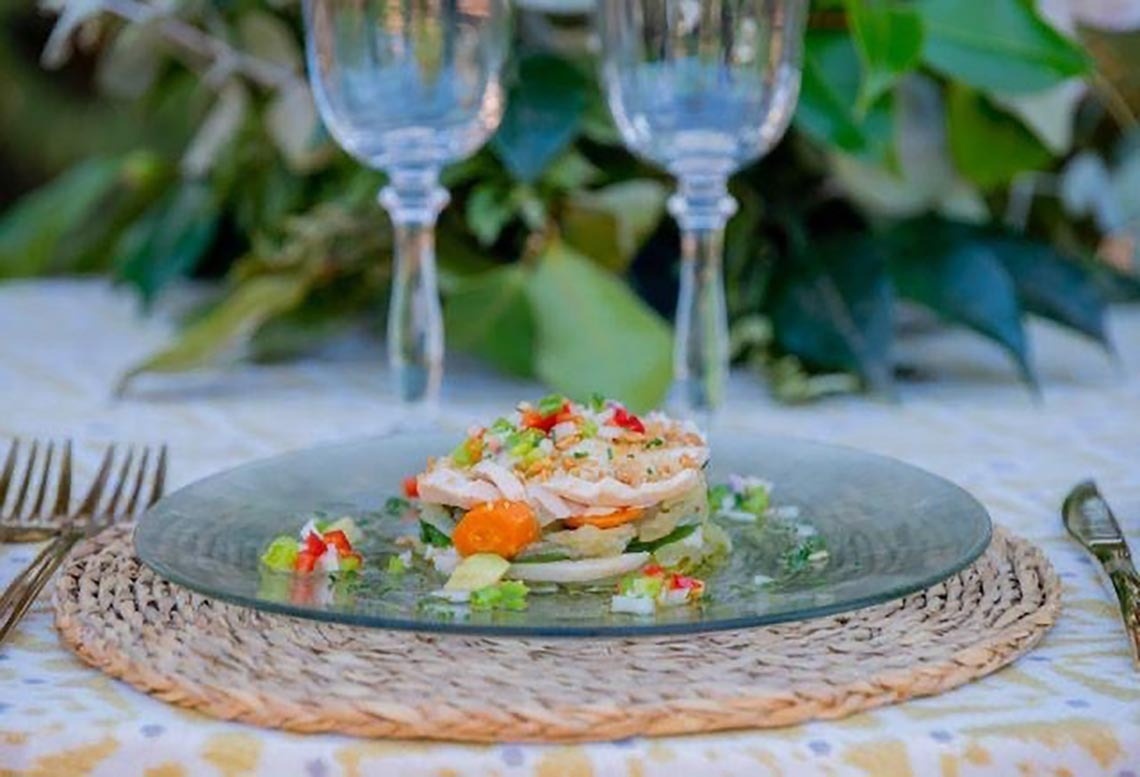 a close up of a plate of food on a table with wine glasses .