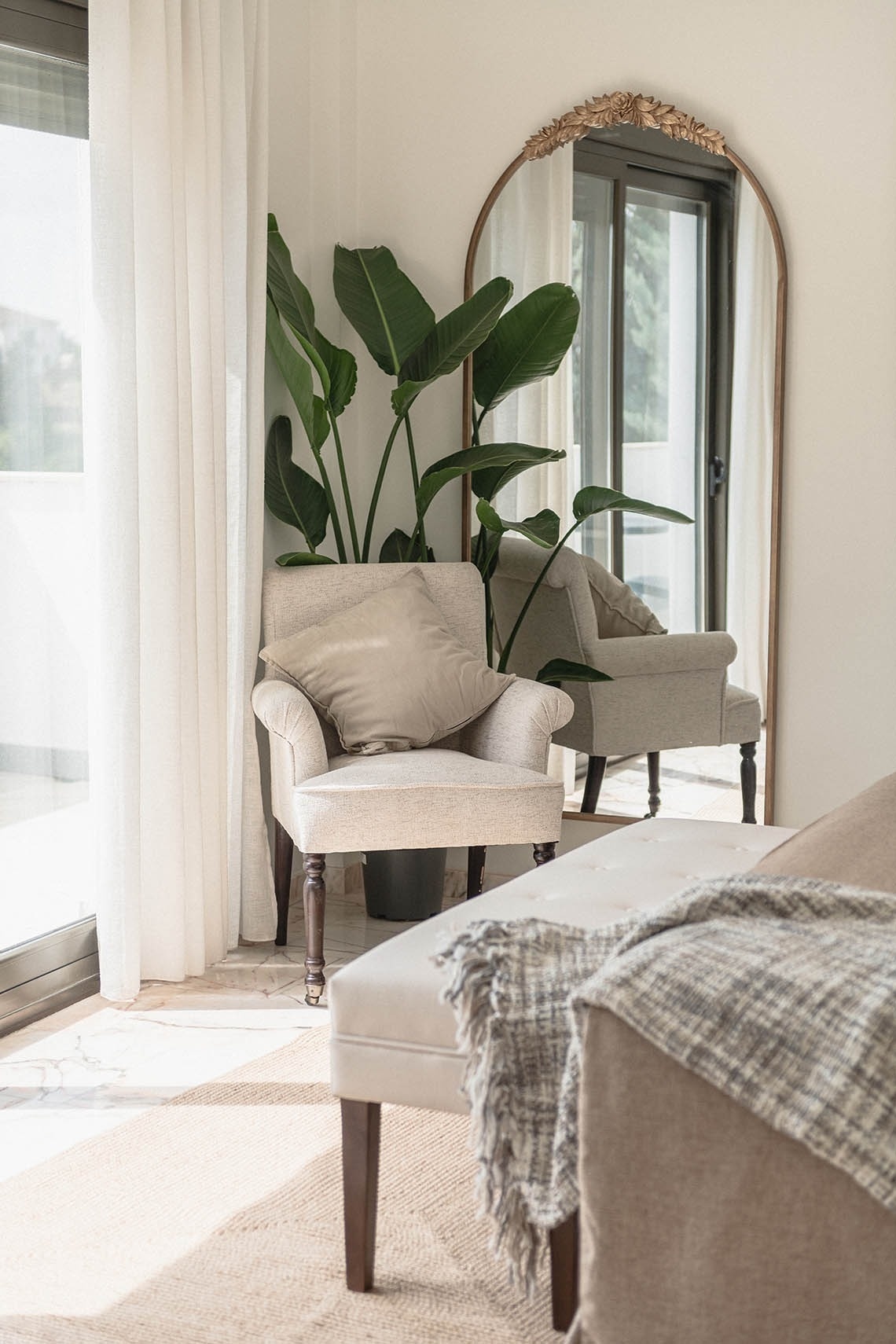 a living room with a chair and a large mirror