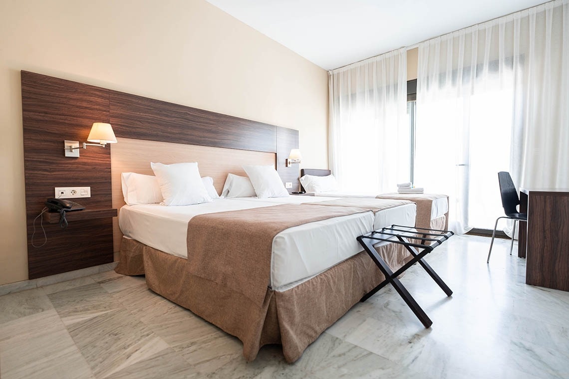 una habitación de hotel con dos camas y una mesa