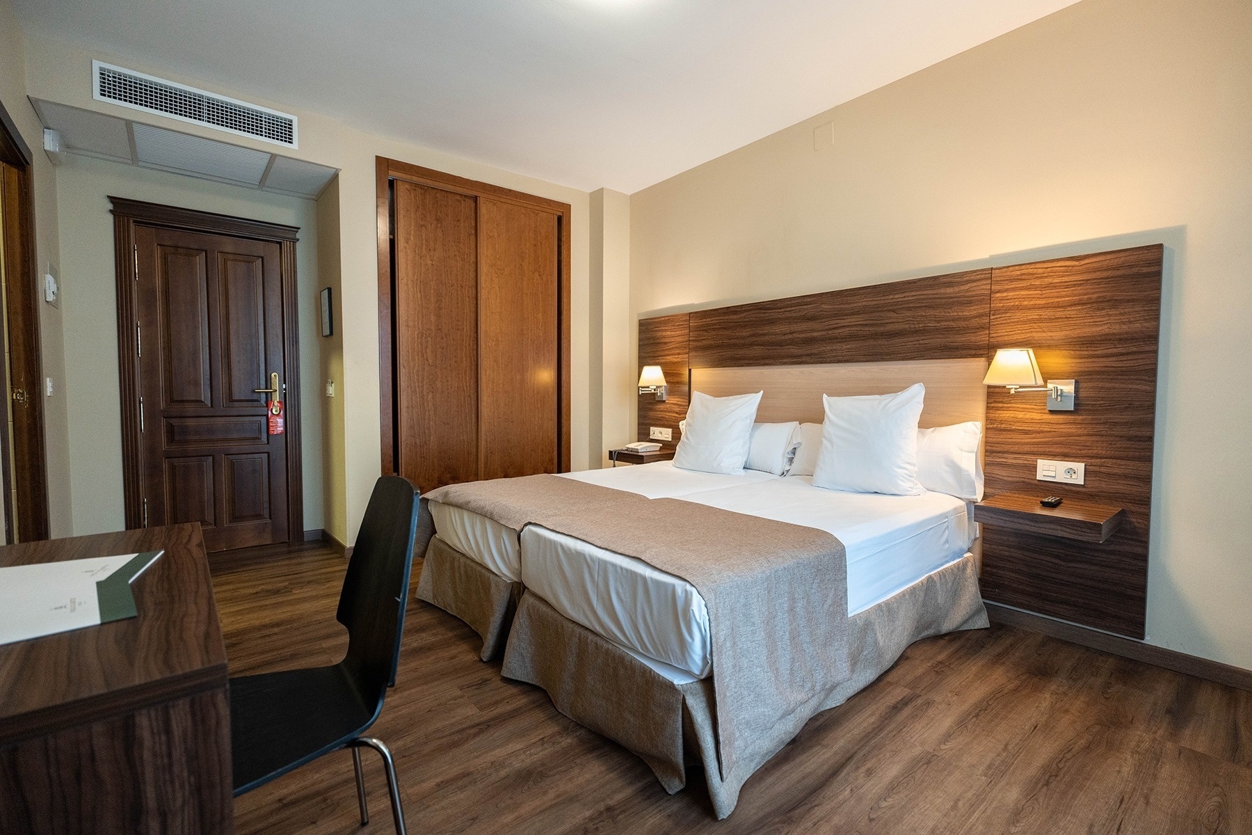 a hotel room with two beds and a desk
