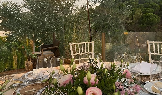 una mesa con flores rosas y una lámpara en el fondo