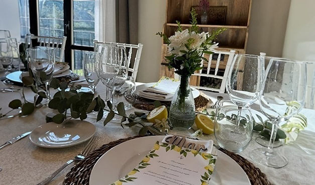 una mesa con platos y copas y un menú con limones