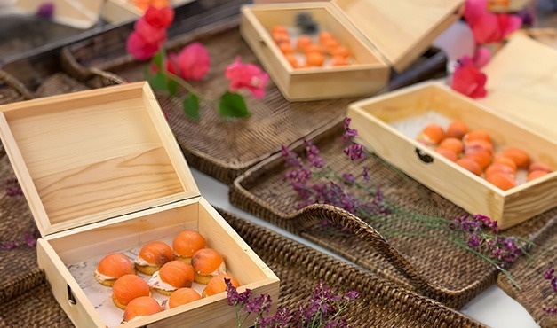 a wooden box filled with food sits on a wicker tray