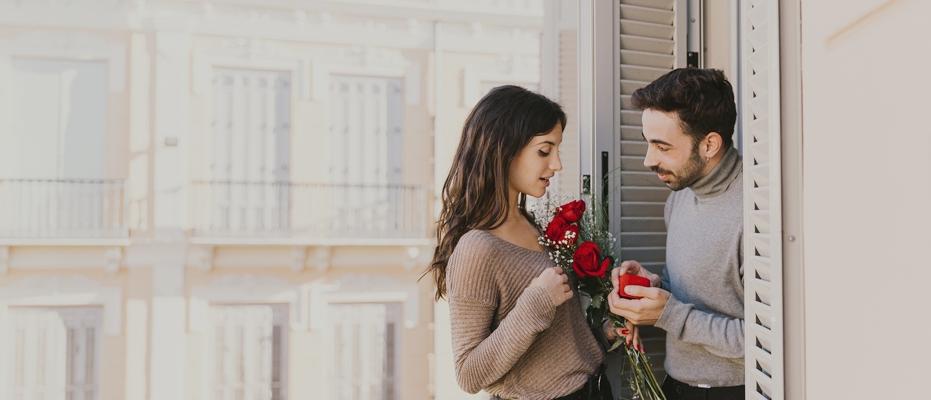 a man is giving a woman a bouquet of red roses