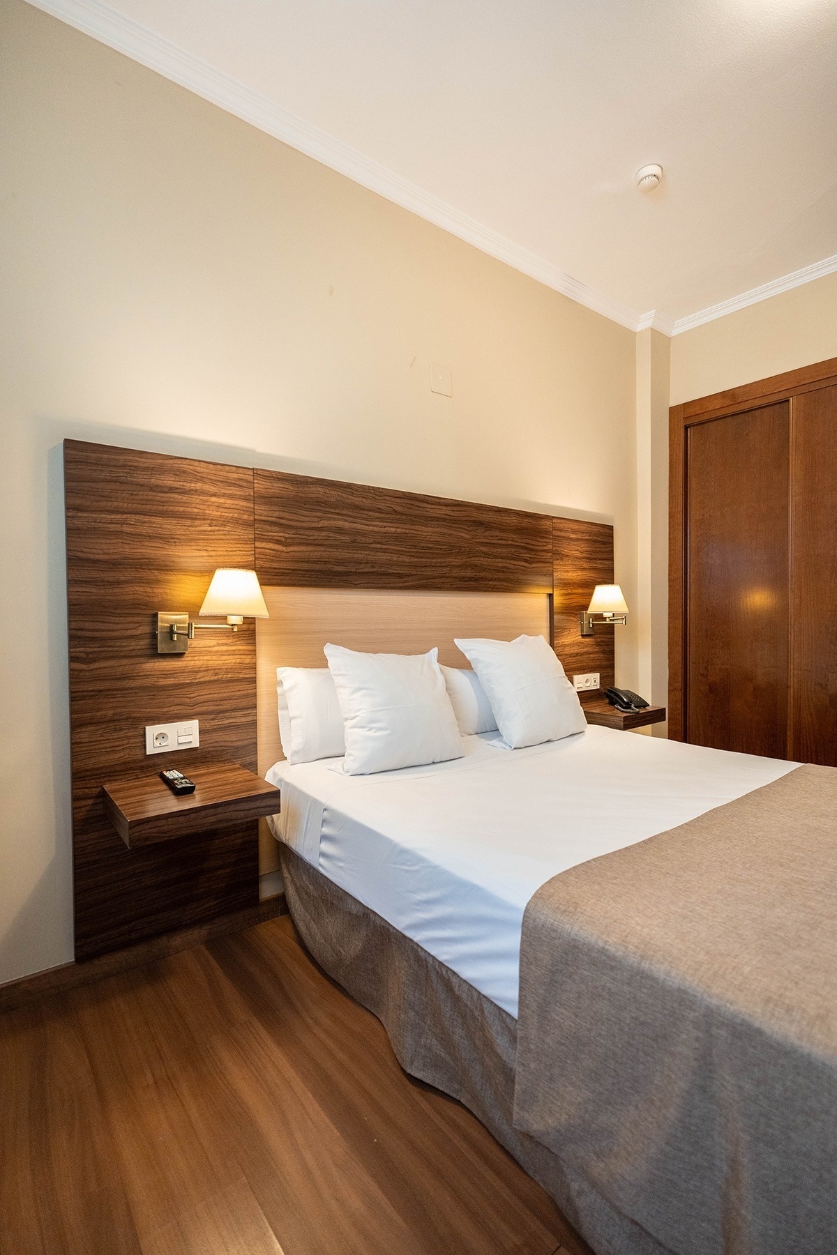 a hotel room with a king size bed and a wooden headboard