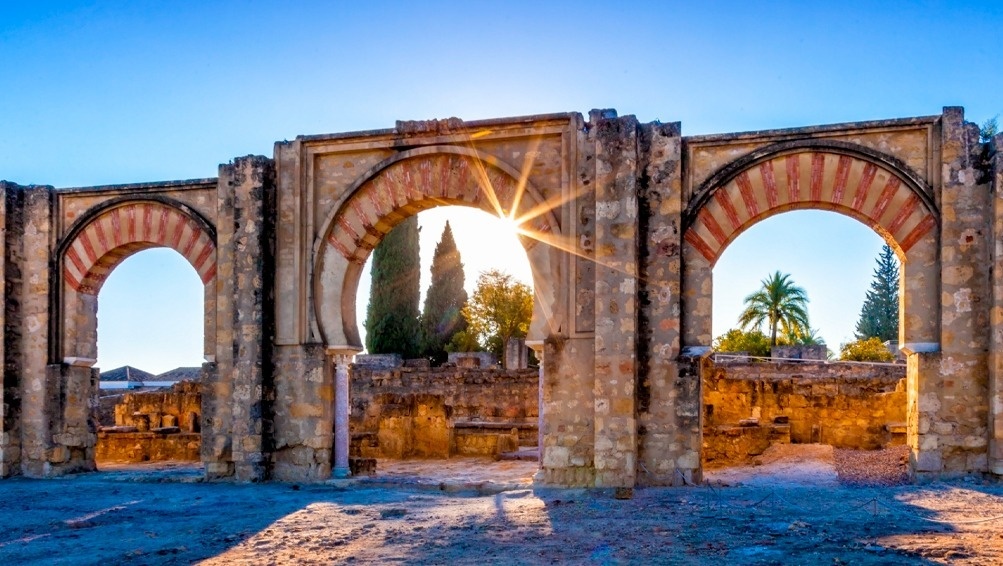 the sun is shining through the arches of an old building