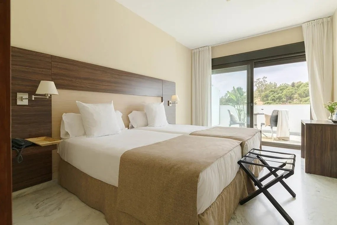 una habitación de hotel con dos camas y una ventana