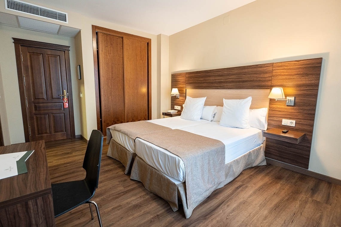 a hotel room with two beds and a desk