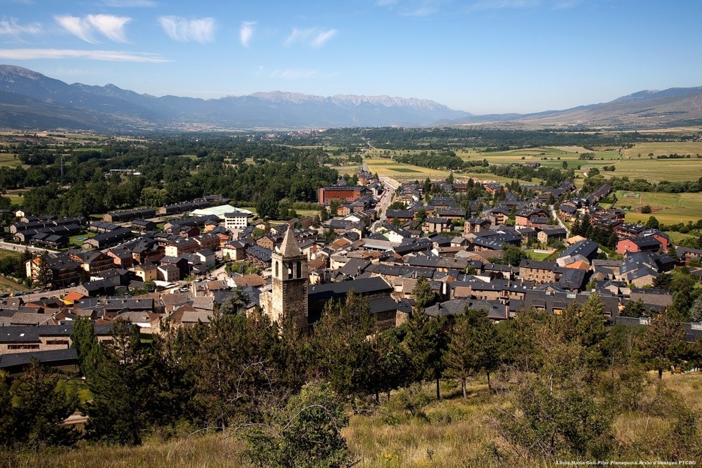 an aerial view of a small town with mountains in the background