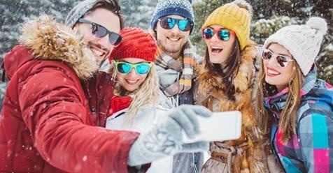 a group of people are taking a selfie in the snow .