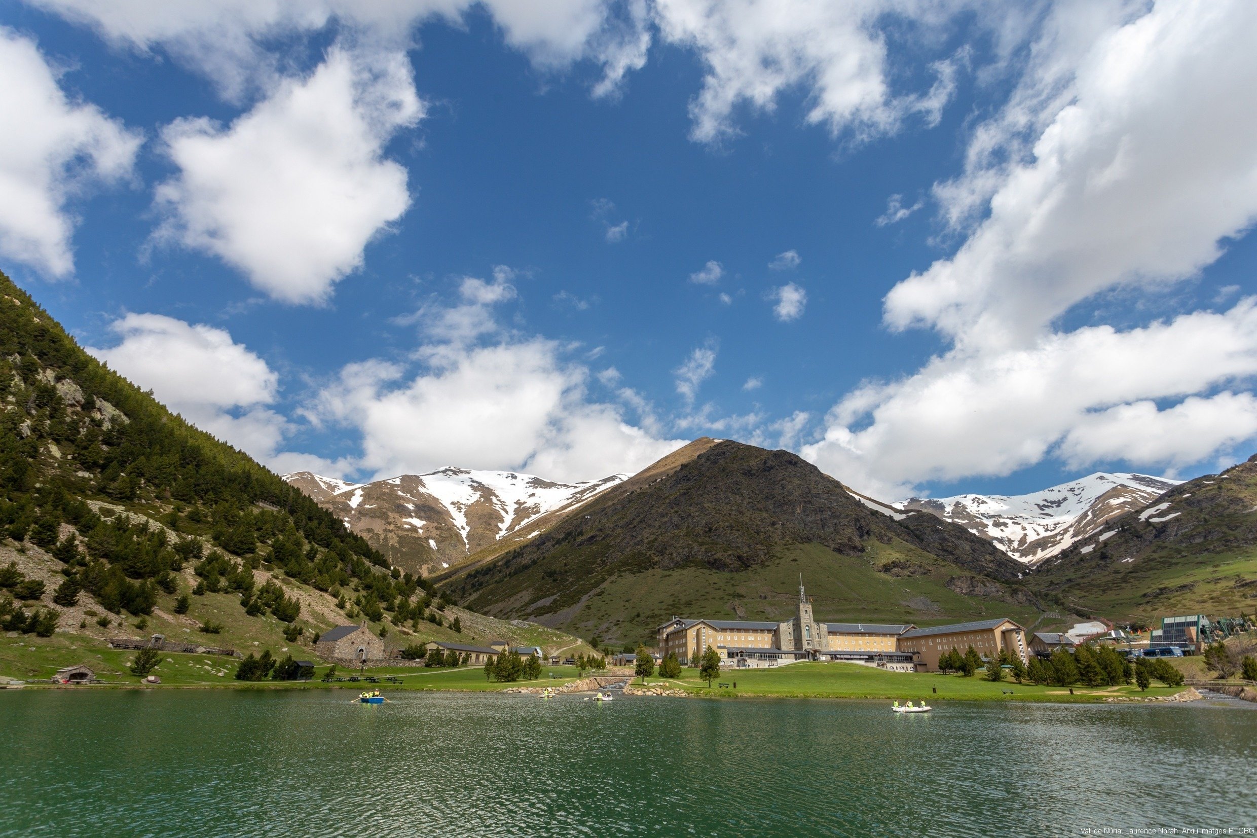 a lake with mountains in the background and a church in the foreground