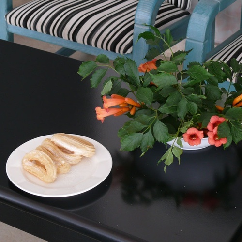 Churros and orange flowers on black table, Torre Cristina.