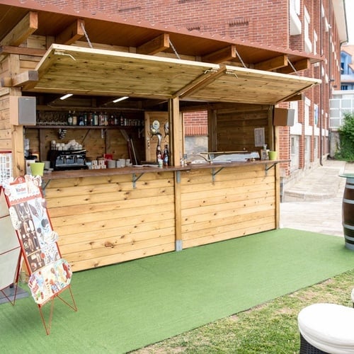 Outdoor wooden bar at Torre Cristina with tables.