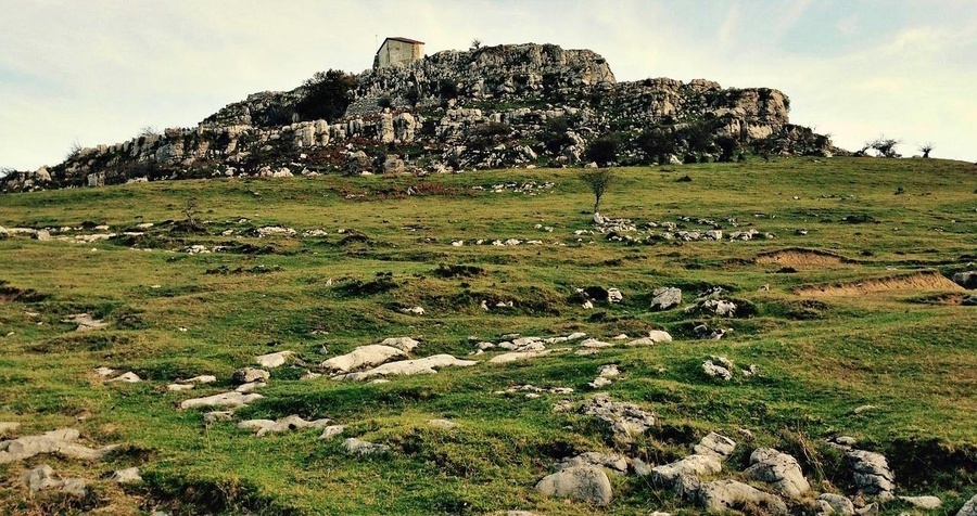 una vista aérea de una playa con un pequeño pueblo en la distancia .