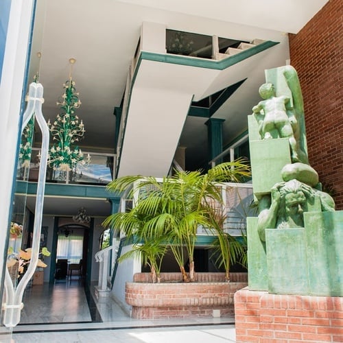 Modern sculpture and green chandelier in the lobby of Torre Cristina Hotel.