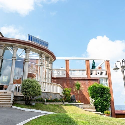 Hotel Torre Cristina: facade with entrance, stairs, and garden. Sea views.