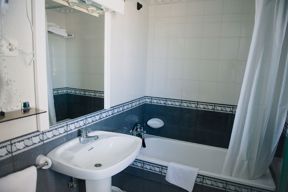 un baño con un lavabo y una bañera y una cortina de ducha