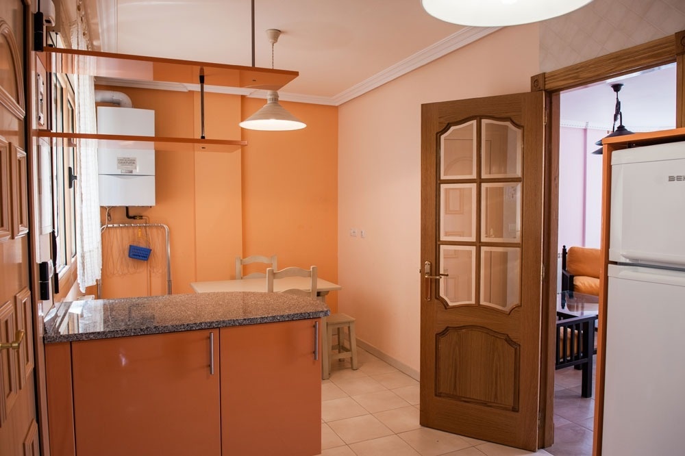 a kitchen with orange cabinets and a bosch refrigerator